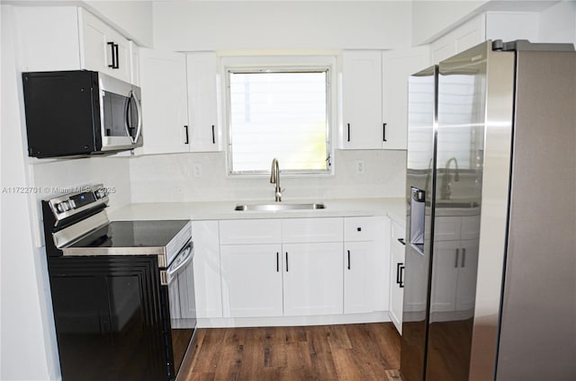 kitchen featuring stainless steel appliances, white cabinetry, sink, and backsplash