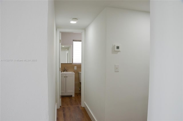 corridor featuring sink and dark hardwood / wood-style flooring