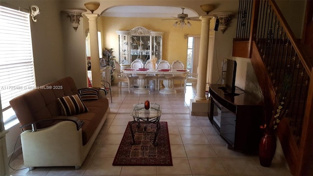 tiled living room featuring ceiling fan and ornate columns