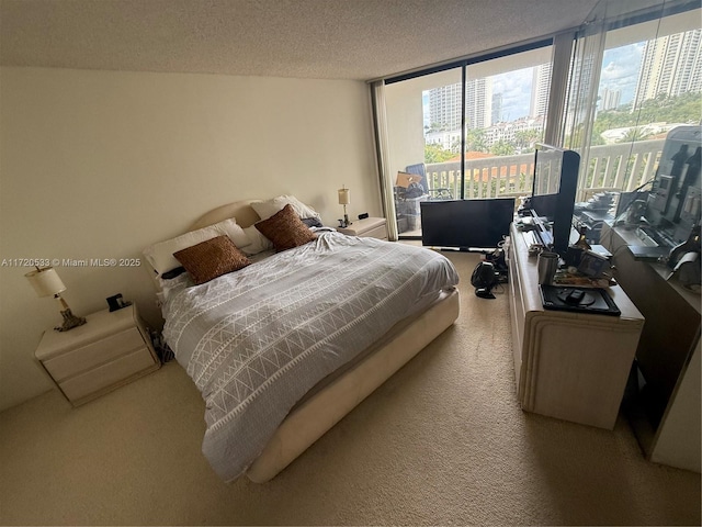 bedroom featuring a textured ceiling, access to outside, and light colored carpet