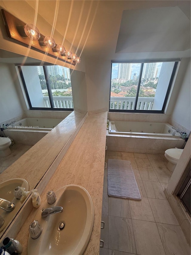 bathroom featuring toilet, tiled tub, tile patterned flooring, and a wealth of natural light