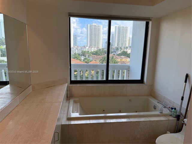 bathroom featuring tiled tub and a wealth of natural light