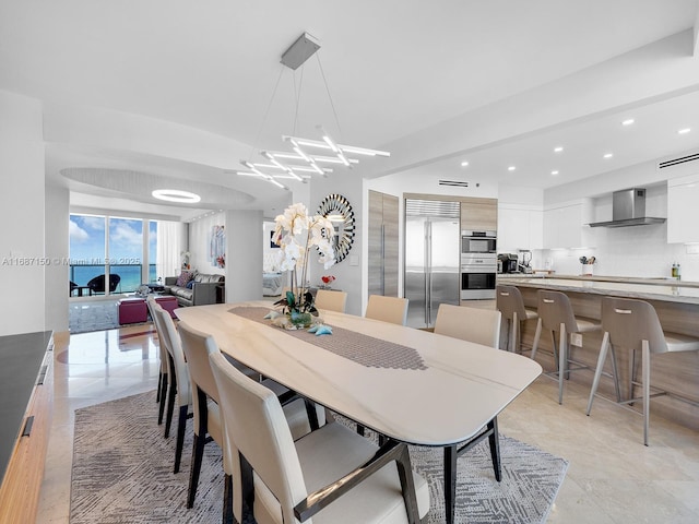 tiled dining space featuring a notable chandelier and a water view