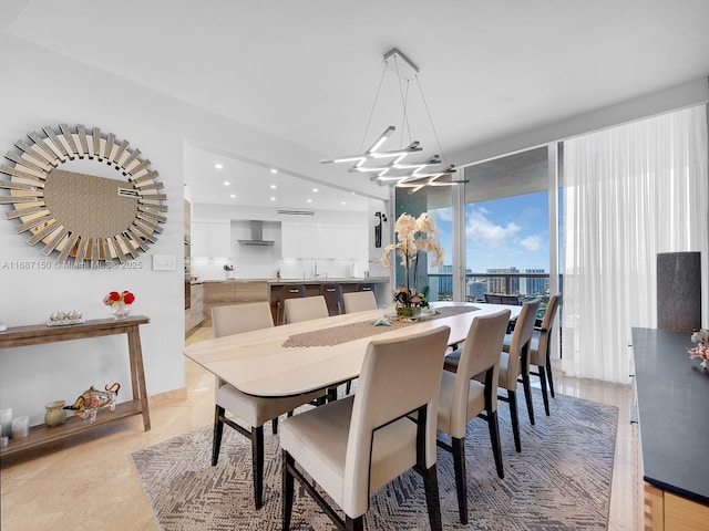 dining area featuring a wall of windows, an inviting chandelier, and sink