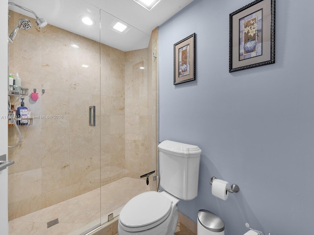 bathroom with toilet and a shower with door