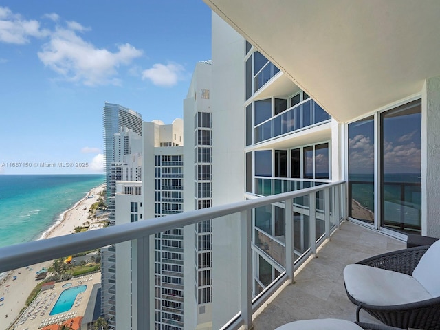 balcony featuring a water view and a beach view