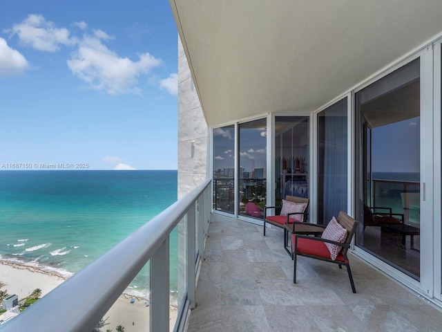 balcony with a water view and a beach view