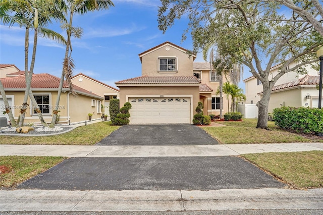 mediterranean / spanish-style home featuring a front yard and a garage