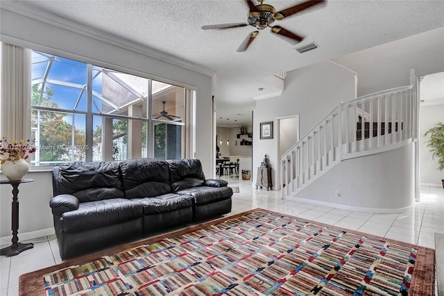 tiled living room with ceiling fan and a textured ceiling