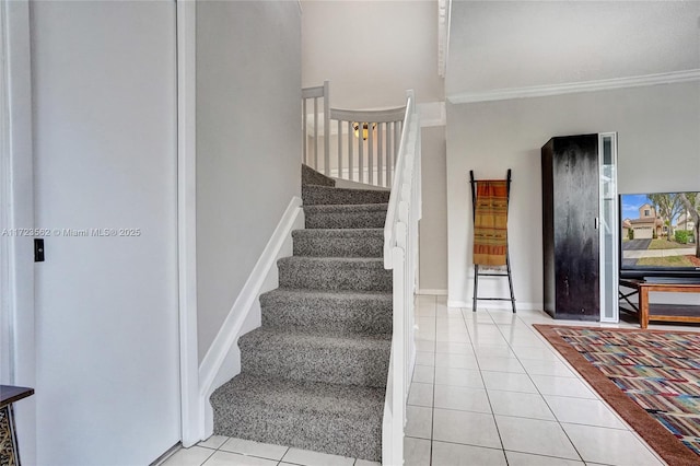 staircase featuring tile patterned flooring and crown molding