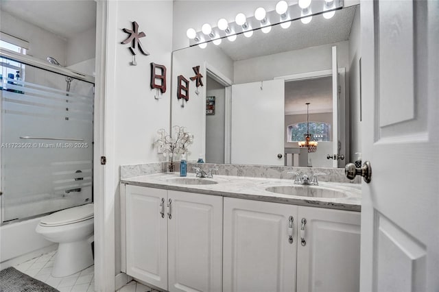 full bathroom featuring toilet, vanity, and shower / bath combination with glass door