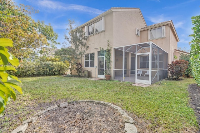 rear view of property with a yard and a lanai