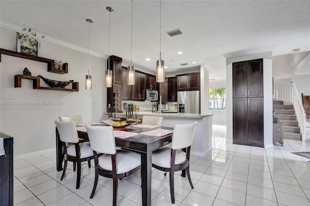 tiled dining area with crown molding and a textured ceiling