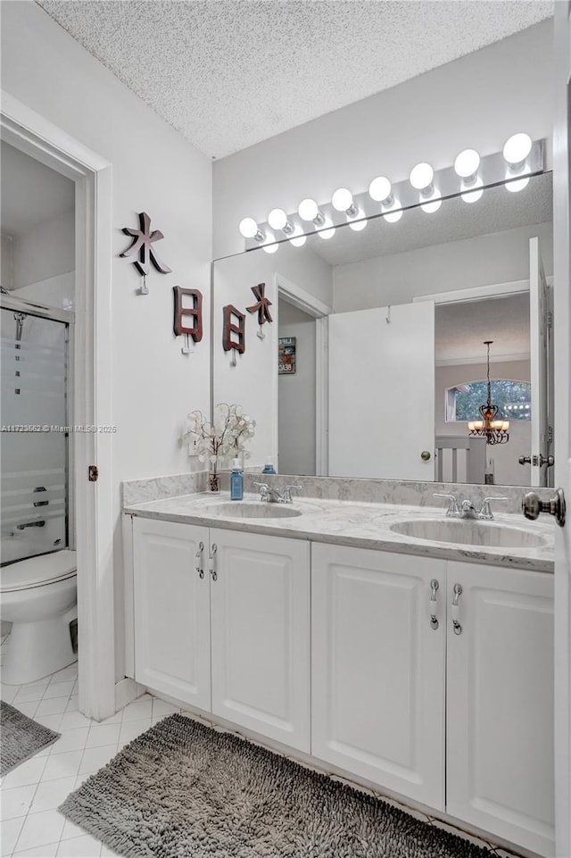 bathroom with a shower with door, tile patterned flooring, vanity, a textured ceiling, and toilet