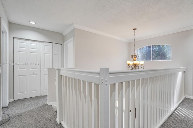 hallway featuring crown molding, carpet floors, and a notable chandelier