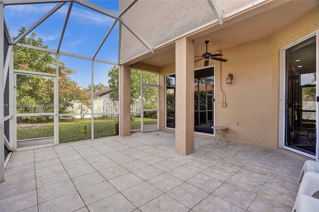 unfurnished sunroom featuring ceiling fan