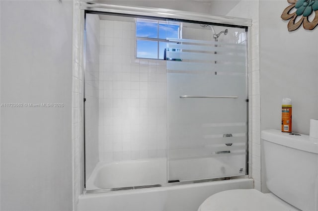 bathroom with shower / bath combination with glass door and toilet