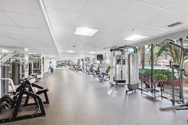 exercise room featuring a drop ceiling and expansive windows