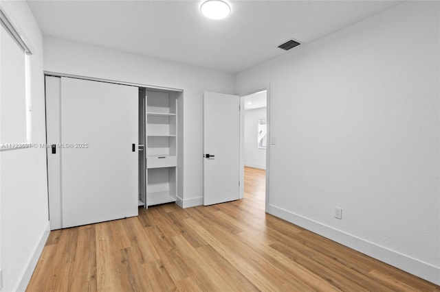 unfurnished bedroom with light hardwood / wood-style floors and a closet