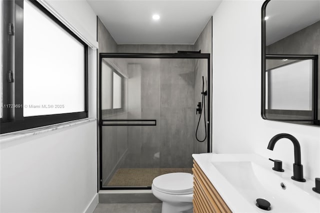 bathroom featuring vanity, a shower with shower door, and toilet