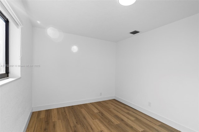 unfurnished room with plenty of natural light and hardwood / wood-style floors