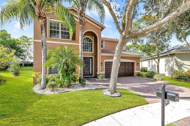 mediterranean / spanish-style house featuring a garage and a front yard