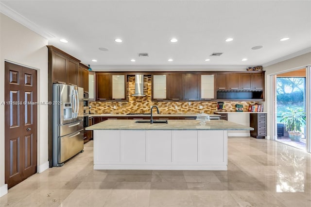 kitchen with stainless steel fridge with ice dispenser, an island with sink, light stone countertops, wall chimney exhaust hood, and sink