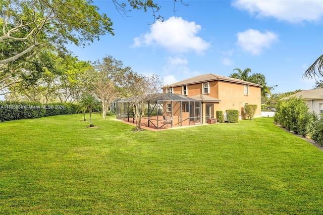 rear view of property with a yard and glass enclosure