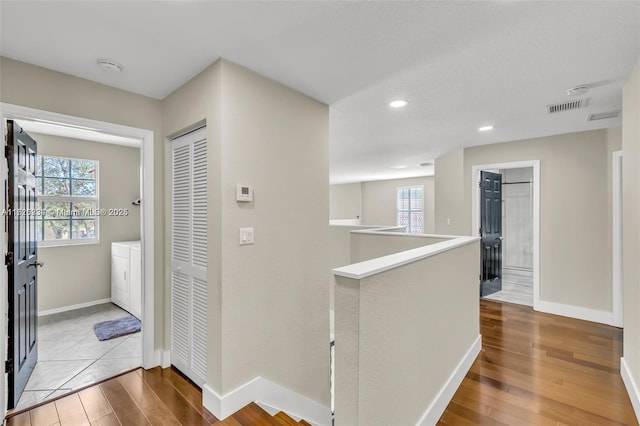 corridor featuring washer / clothes dryer and hardwood / wood-style floors