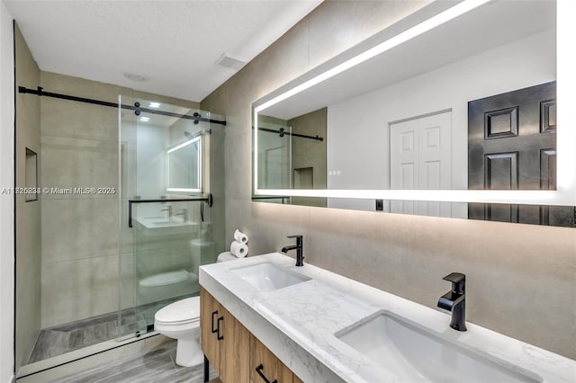 bathroom with toilet, walk in shower, tasteful backsplash, hardwood / wood-style floors, and vanity