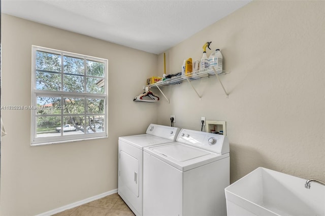 washroom with sink, light tile patterned flooring, and independent washer and dryer