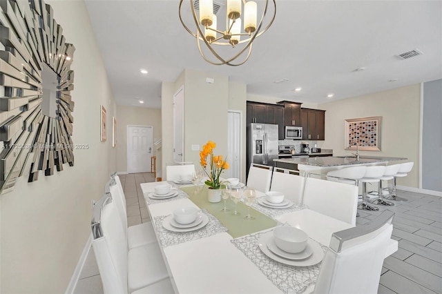 dining room with sink and a chandelier