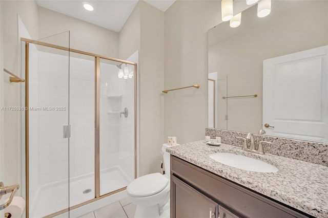 bathroom with toilet, vanity, tile patterned floors, and a shower with shower door