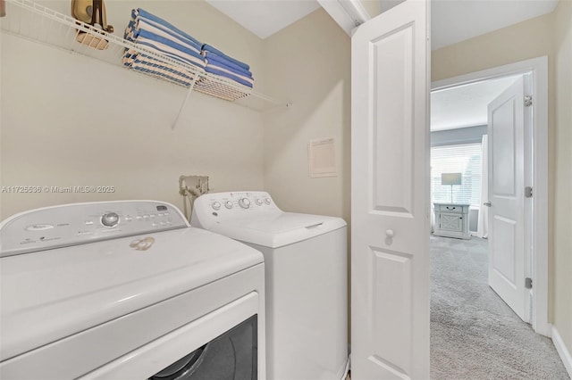 clothes washing area featuring separate washer and dryer and light colored carpet