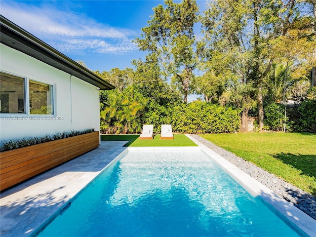 view of pool with a yard and a patio