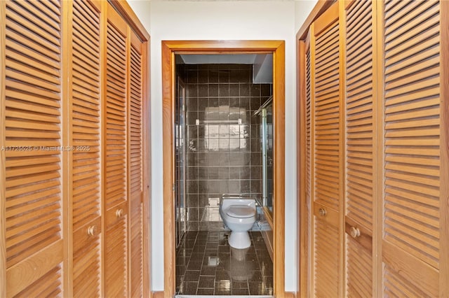 bathroom featuring toilet and tile walls