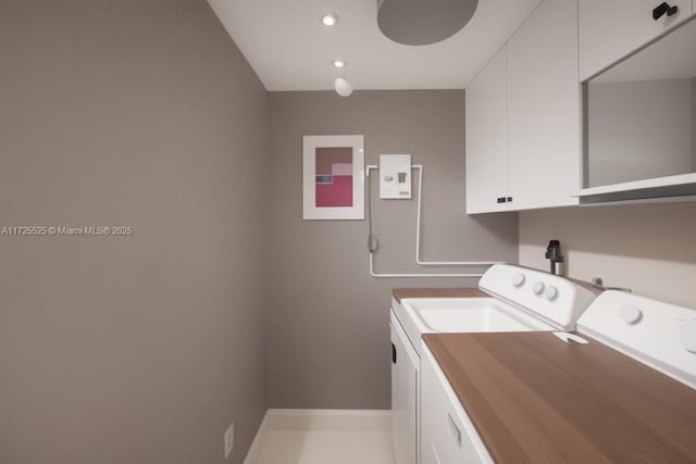 laundry room featuring cabinets and washer and clothes dryer