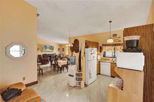 kitchen with light tile patterned flooring, white appliances, lofted ceiling, and decorative light fixtures