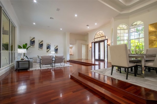 living area featuring baseboards, crown molding, and wood finished floors