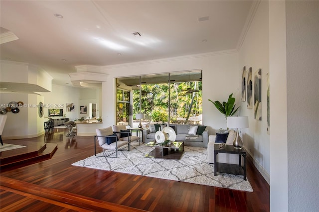 living room with baseboards, wood finished floors, and crown molding