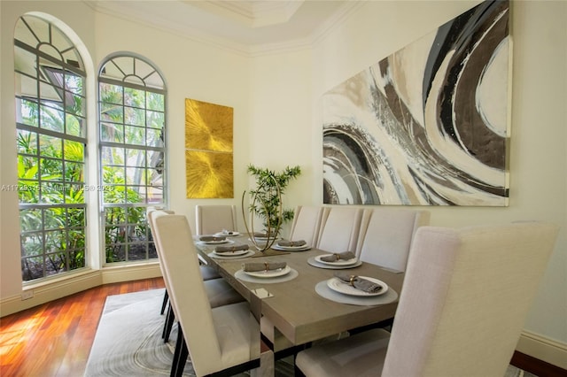 dining space with ornamental molding and wood finished floors