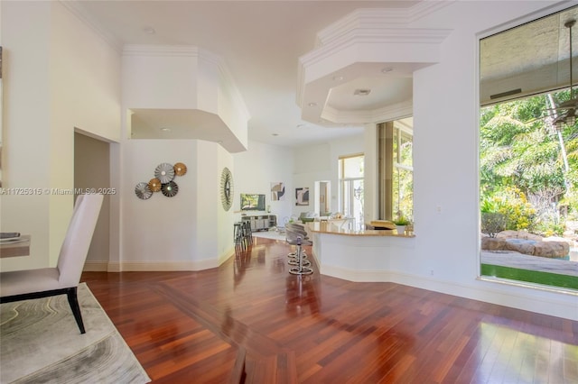 interior space with ornamental molding, baseboards, and wood finished floors