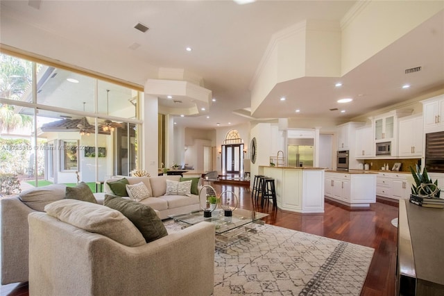 bar featuring baseboards, crown molding, wood finished floors, and visible vents