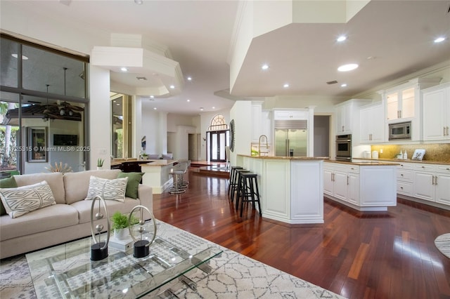 living room featuring dark wood finished floors, crown molding, and recessed lighting