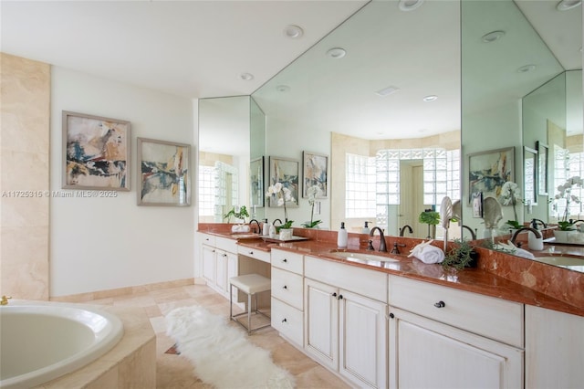 full bathroom with a garden tub, plenty of natural light, vanity, and tile patterned floors