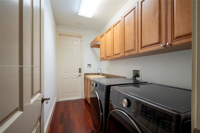 laundry room with cabinet space, baseboards, dark wood finished floors, washer and clothes dryer, and a sink