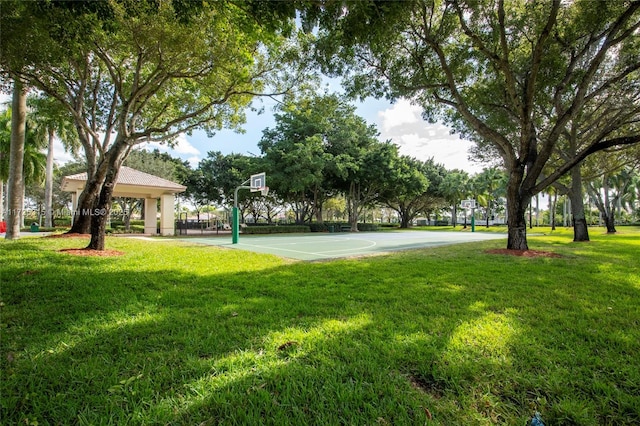 view of property's community with community basketball court and a yard