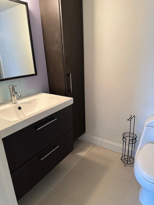 bathroom with tile patterned flooring, vanity, and toilet