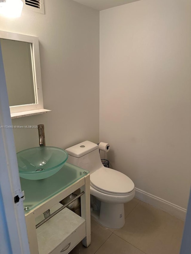 bathroom featuring toilet, tile patterned floors, and vanity