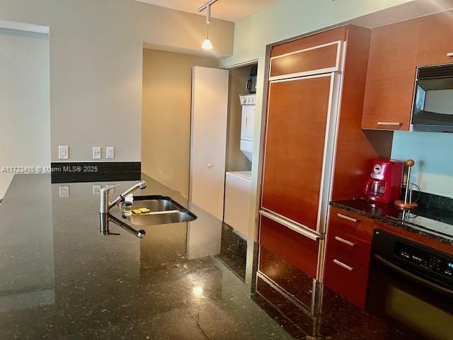 kitchen featuring sink, hanging light fixtures, black appliances, and dark stone counters